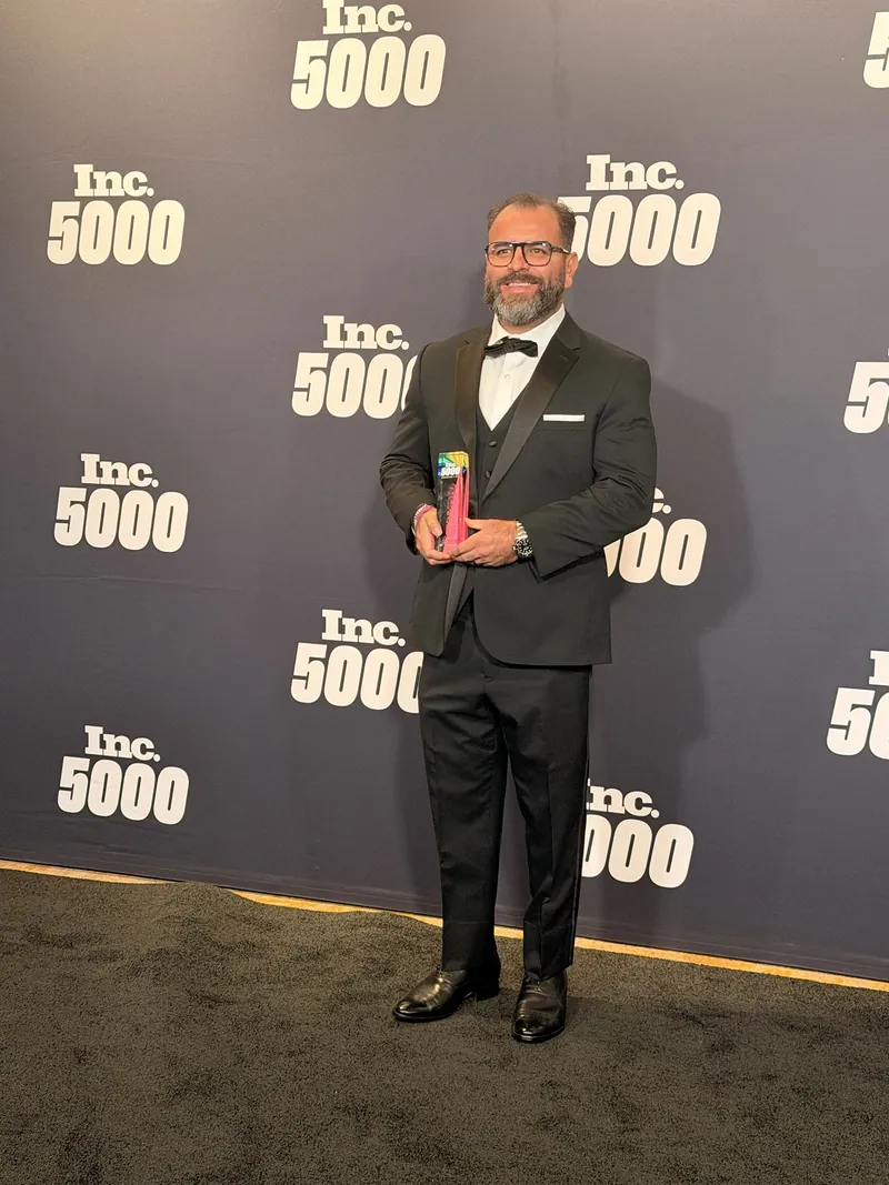 Steven F. Gonzalez holding HealthView's Inc. 5000 award in front of the Inc. 5000 backdrop